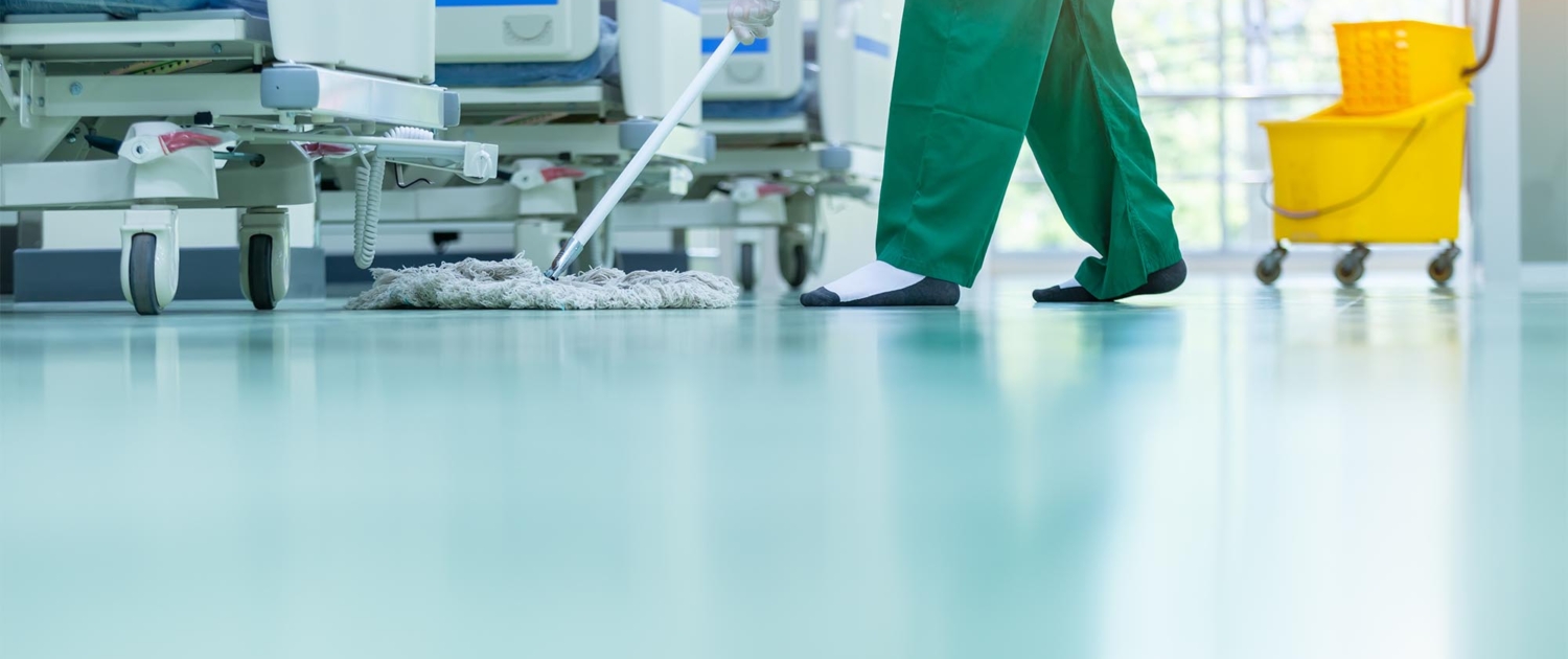 Nurse mopping concrete floor in hospital room